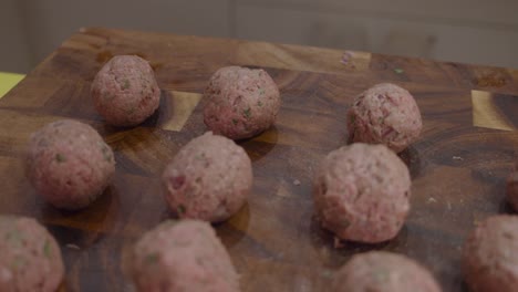 albóndigas frescas en tabla cortada de madera