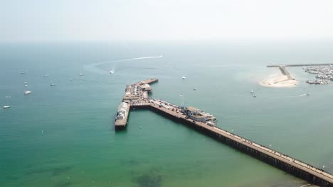 muñeca aérea hacia el muelle de santa barbara con cielos azules y agua, así como barcos en el agua