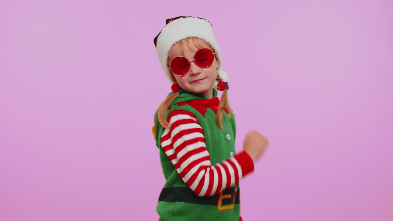 Dívka, vánoční skřítek Santa Clause, poslouchá hudbu přes sluchátka, tančí disko, blbne a baví se