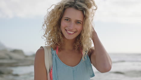 Retrato-De-Una-Hermosa-Mujer-Rubia-Sonriendo-En-La-Playa-Tocando-El-Cabello