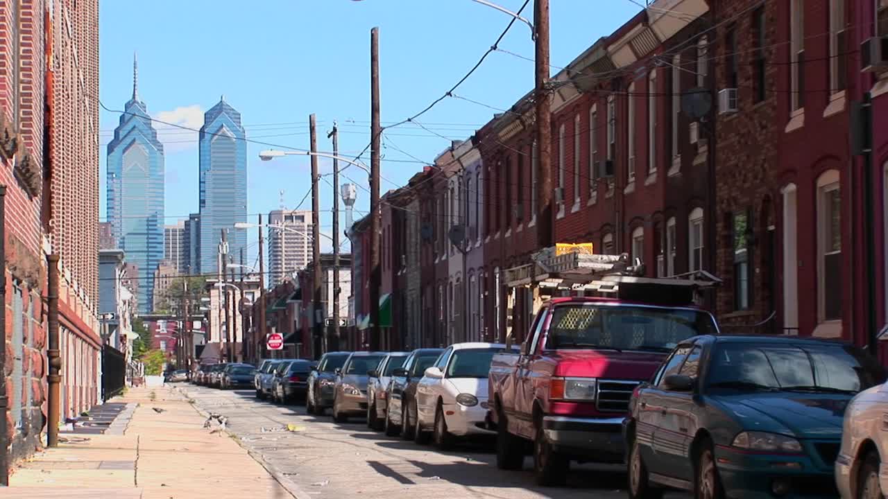 필라델피아 펜실베니아 2의 벽돌 건물 거리를 따라 차량이 주차되어 있습니다.