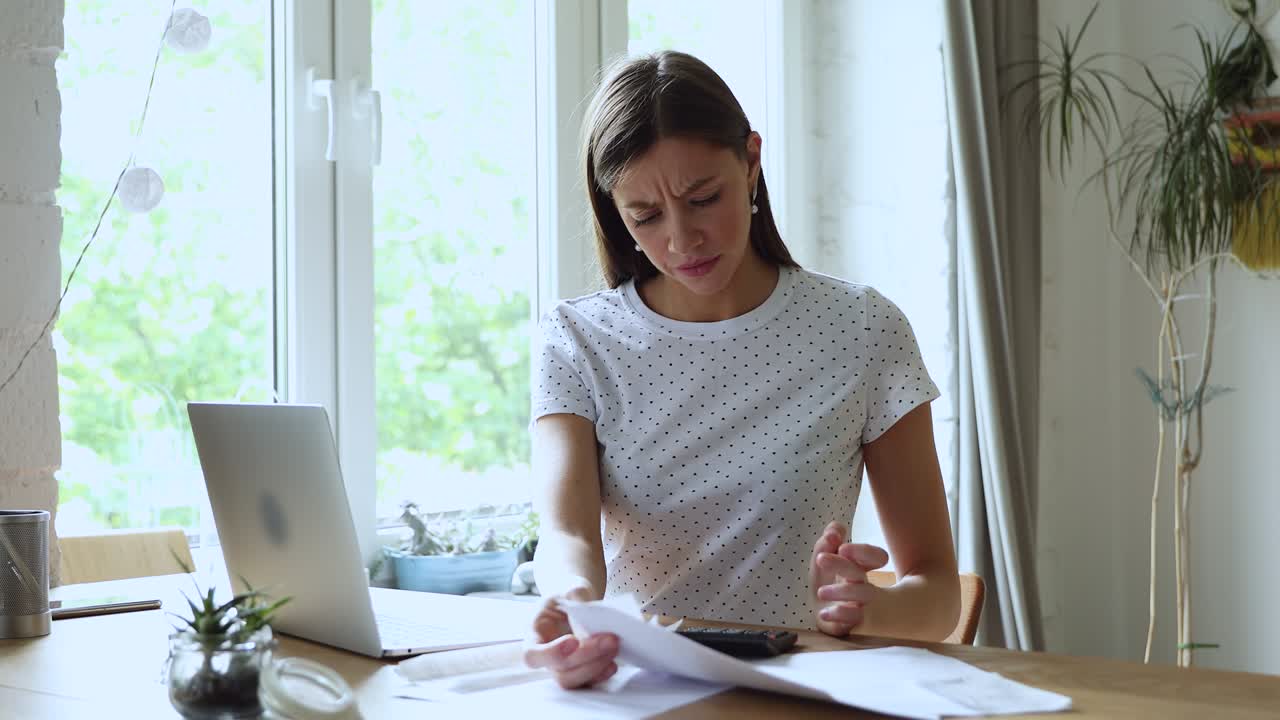 una joven estresada haciendo papeleo financiero, teniendo problemas con los pagos.