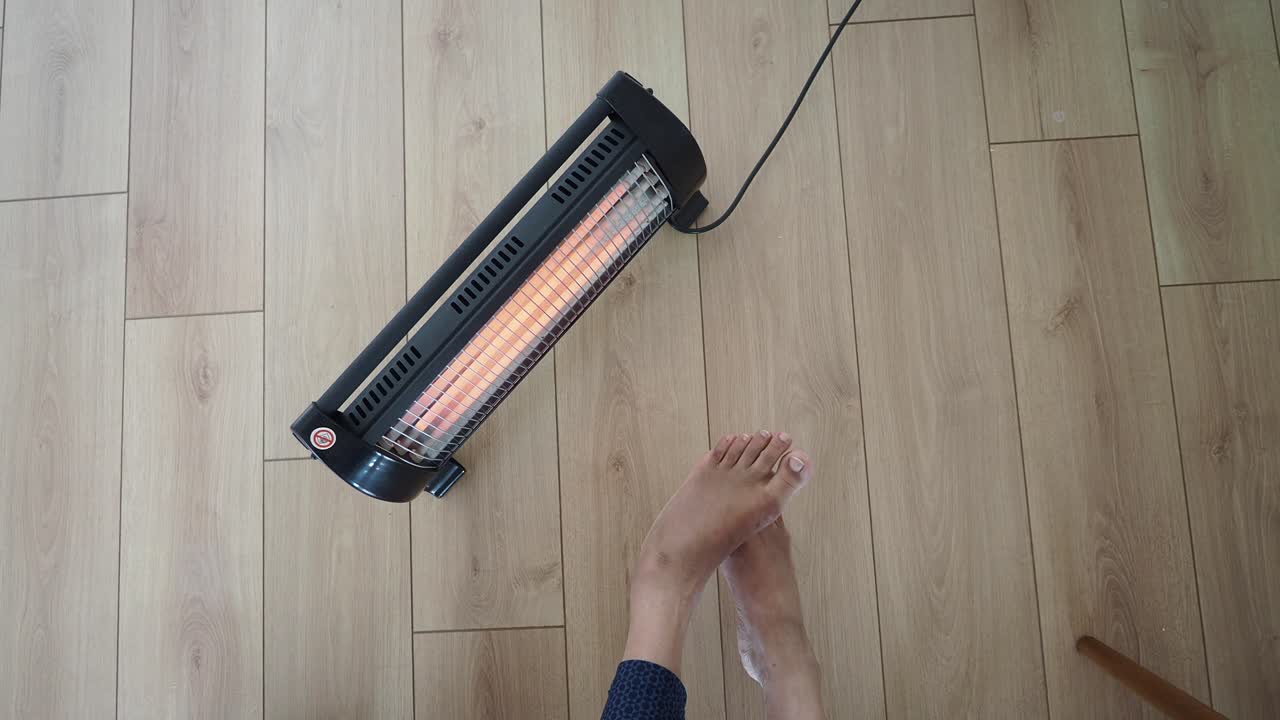 Person warming feet with a portable heater