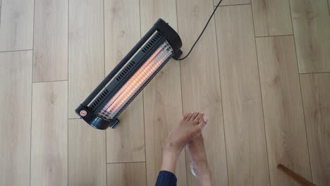 person warming feet with a portable heater