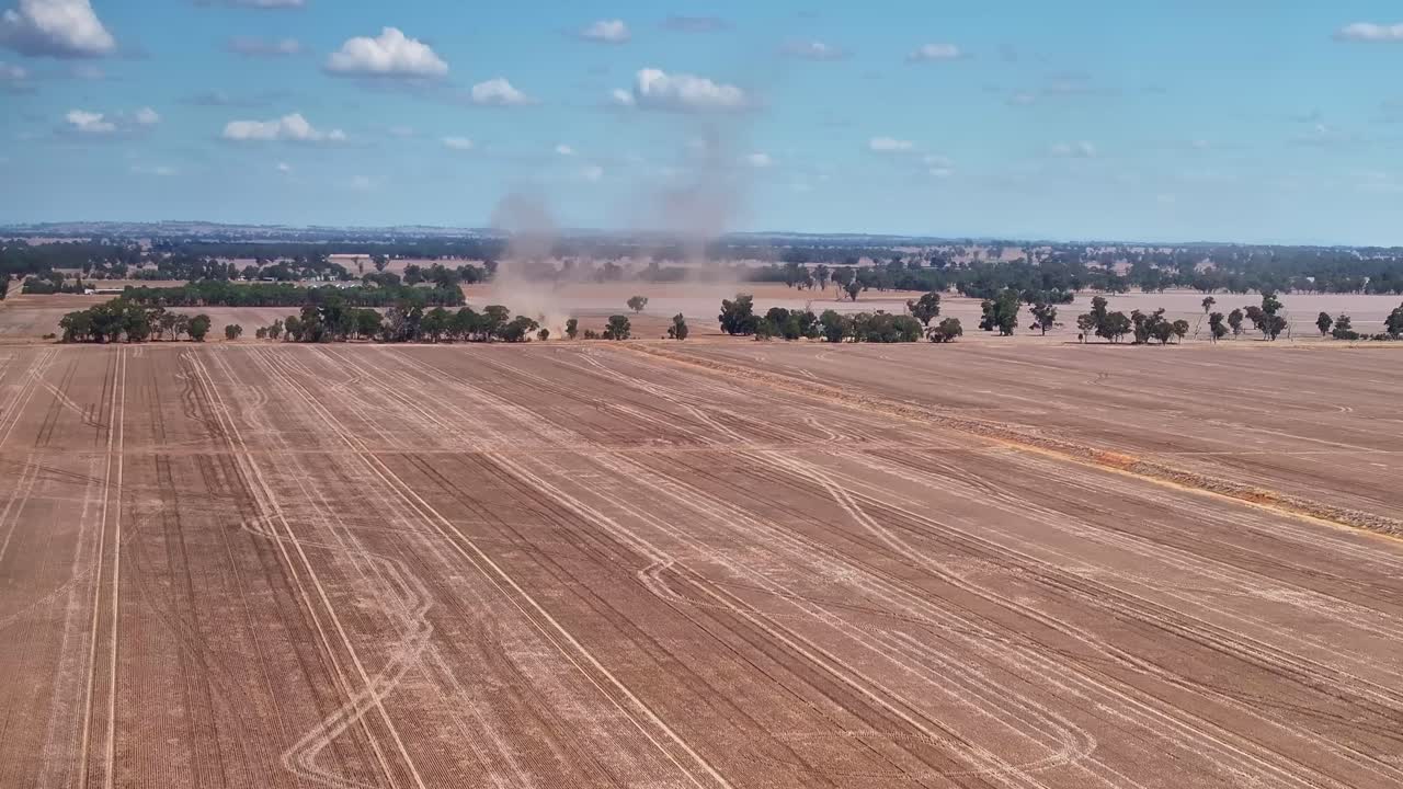 Dust trails over freshly harvested fields in the rural Yarrawonga landscape in Victoria Australia