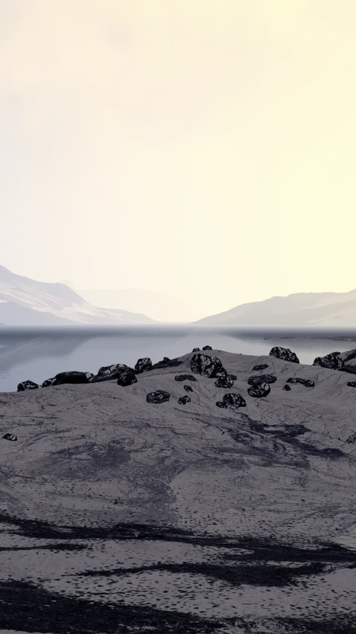 un hermoso paisaje de un lago y montañas con un claro cielo azul y algunas rocas en primer plano