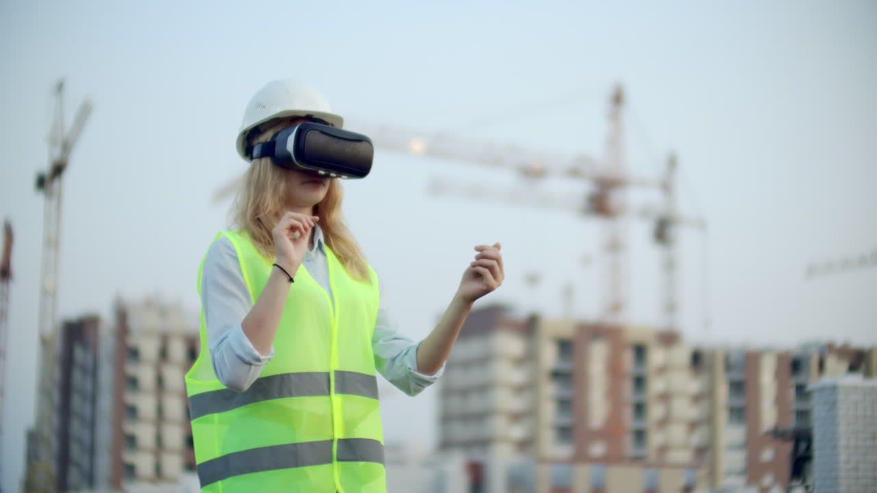 retrato de una mujer que opera una grúa en un sitio de construcción usando gafas de realidad virtual. una mujer gerente de construcción maneja el progreso y el plan de los edificios usando gestos al atardecer