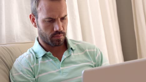 hombres sosteniendo su barbilla mientras miran su computadora portátil