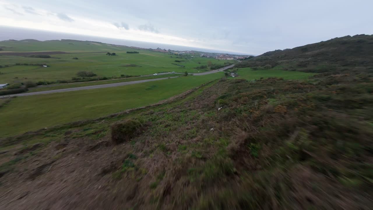 FPV Drone flying down Picota mountain in LIencres (Cantabria) on a cloudy day. At one point some rabbits cross paths as the drone descends at high speed.