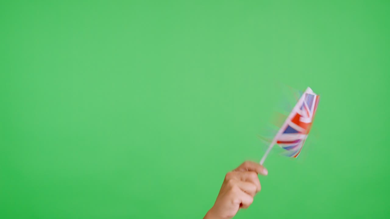 Hånd som vifter med en vimpel med et britisk nasjonalflagg