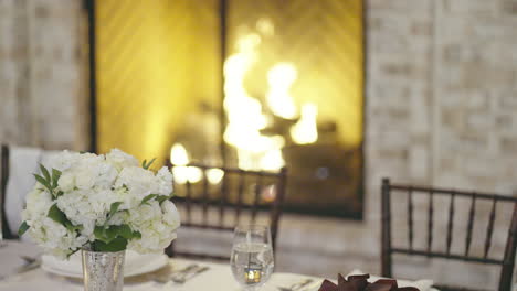 wedding dining table prepared for guests by cozy fireplace