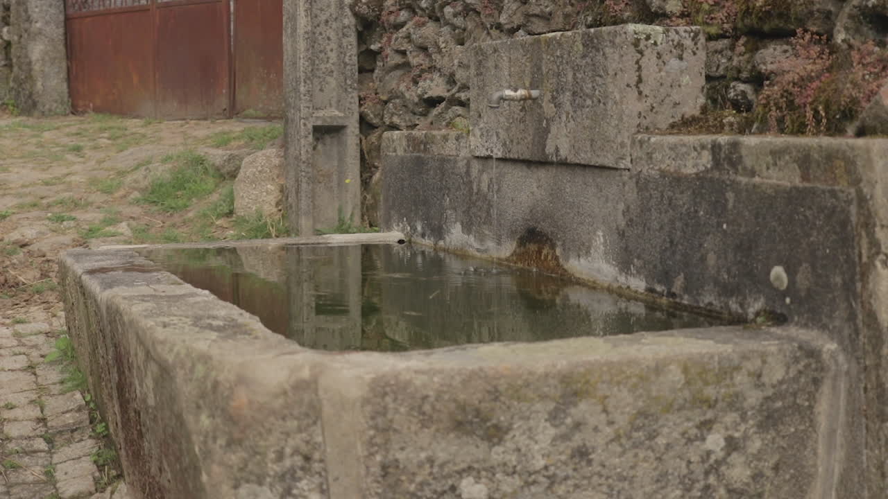 tiro inclinado de un ganado que bebe bien en un pueblo rural en una colina friaes tras-os-montes portugal