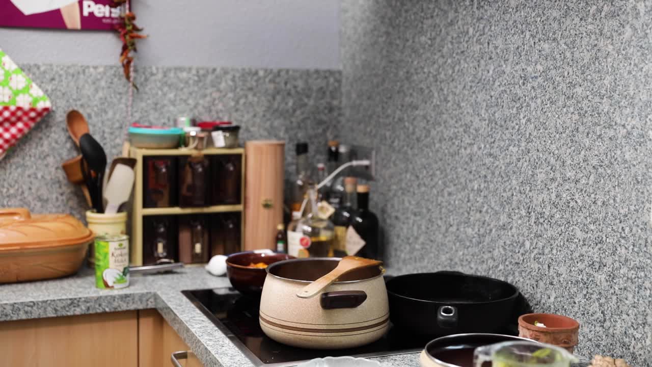 Vapore che sale dalla pentola con un cucchiaio di legno su un fornello elettrico mentre si cucina in cucina