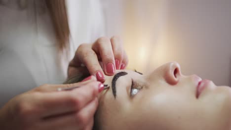 Caucasian-woman-lying-down-having-her-eyebrows-dyed