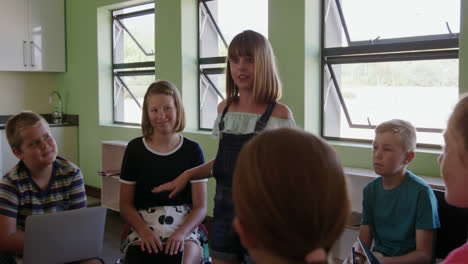 Girl-with-digital-tablet-talking-in-the-class