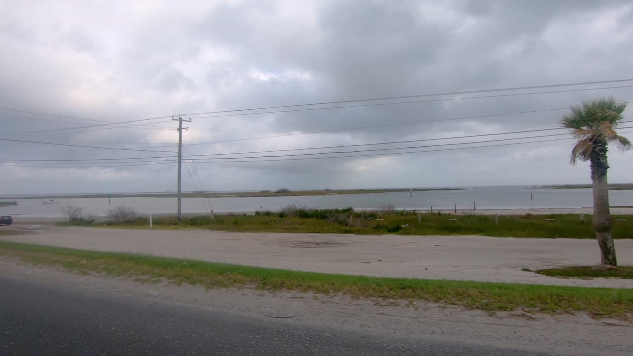 laguna madre 상류에 있는 작은 전리품 섬을 지나고 corpus chrisi texas 근처의 kennedy 기념 둑길로 운전하는 동안 pov