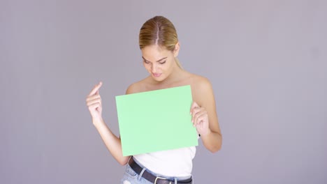 Atractiva-Mujer-Rubia-Sosteniendo-Un-Cartel-Verde-En-Blanco