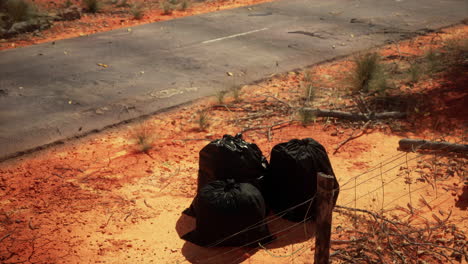 Primer-Plano-De-Bolsas-De-Basura-Llenas-En-La-Arena