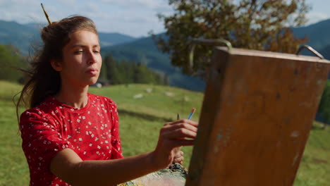 Portrait-girl-painter-drawing-on-easel-summer-day.-Woman-creating-sketch-closeup