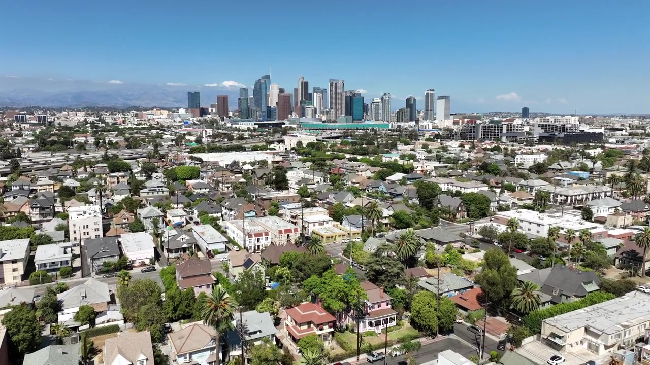 Filmato aereo che mostra lo skyline centrale di Downtown Los Angeles in una luminosa giornata estiva di sole, con alti grattacieli circondati da una vivace zona residenziale