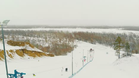 modern-track-with-skiers-on-hill-at-snow-storm-upper-view