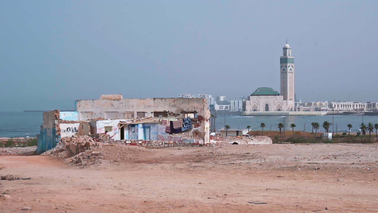 Casa in rovina e moschea di Hassan II sul mare a Casablanca, Marocco.