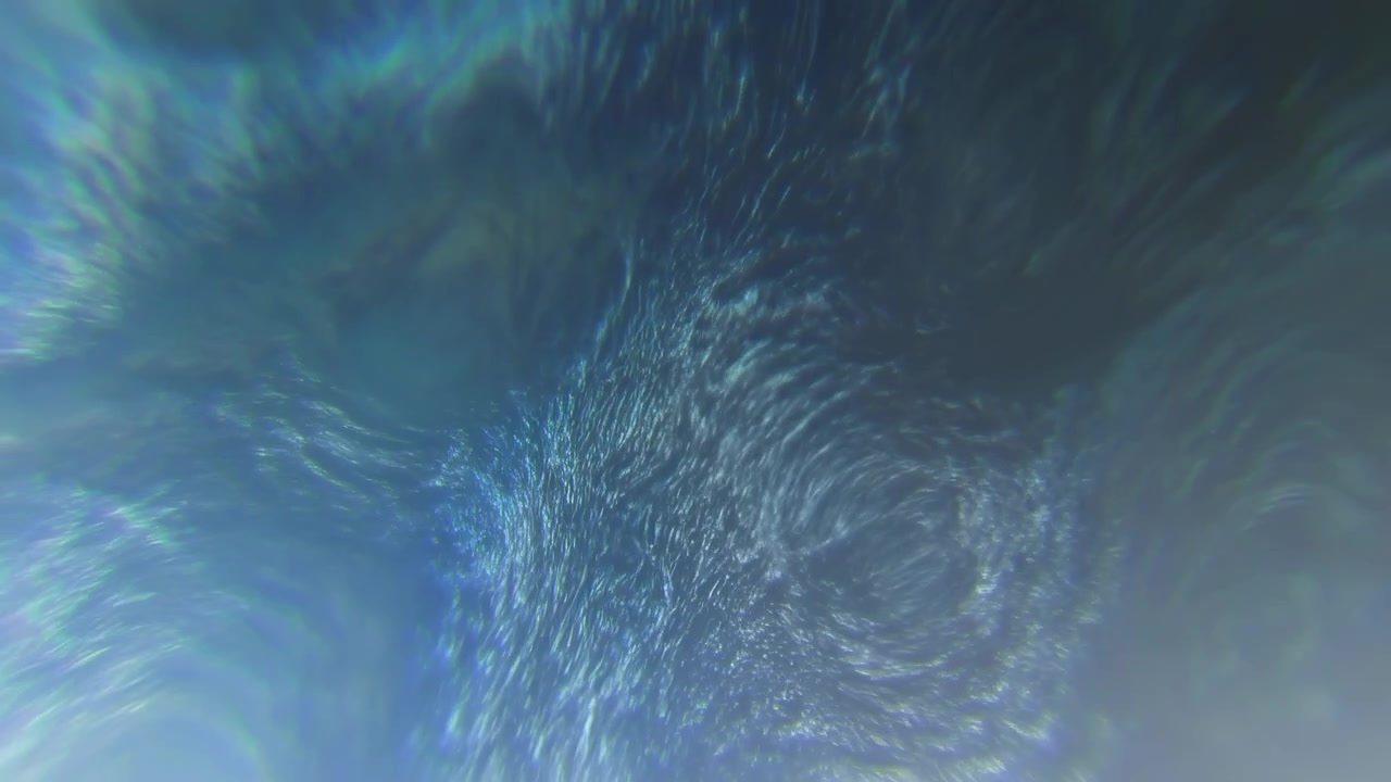Atmospheric cinematic scene showing turbulent ocean surface from high oblique viewpoint with dominant whirlpool near upper-center, dense concentric rings,