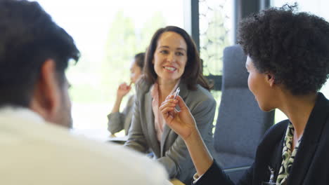 Multi-Cultural-Business-Team-Meeting-And-Collaborating-Around-Table-In-Modern-Office-Building