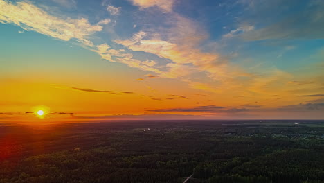 sunset hyperlapse over dense forest landscape with vibrant orange and blue sky