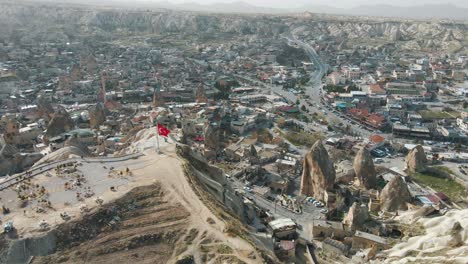Aerial-top-drone-shot-over-the-town-at-the-foothills-in-Cappadocia,-Turkey-at-daytime