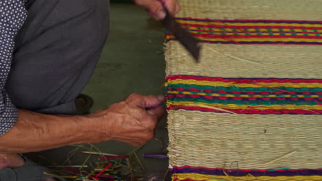 Cutting-loose-strands-from-hand-made-mattress,-close-up