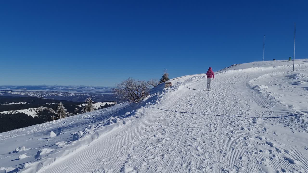 Young woman walking in mountains in ski clothes