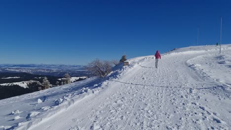 young woman walking in mountains in ski clothes