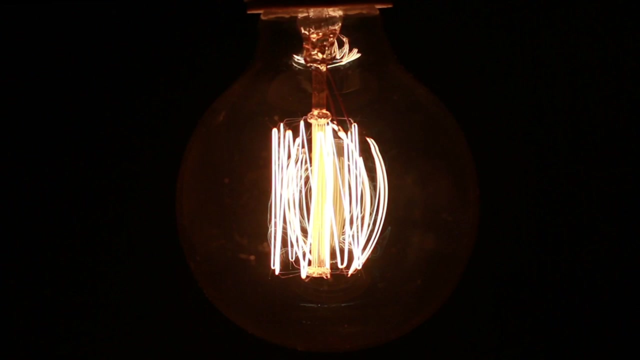 Retro industriële gloeilamp knippert in het donker.