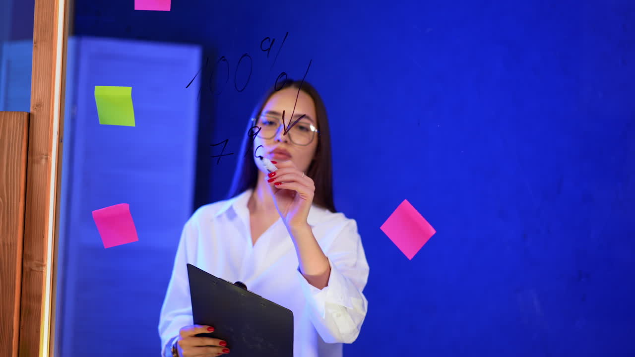 Office brainstorming session. A group member actively participates in a brainstorming session, surrounded by colorful sticky notes on a blue wall