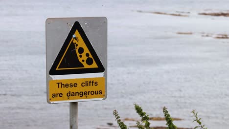 warning sign near cliffs in fife, scotland