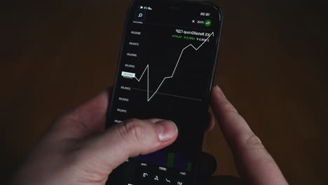 person looking at a stock market graph on a smartphone