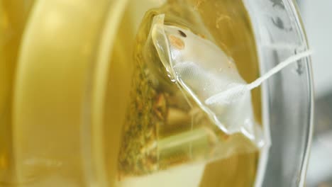 close-up of a tea bag steeping in a cup of herbal tea