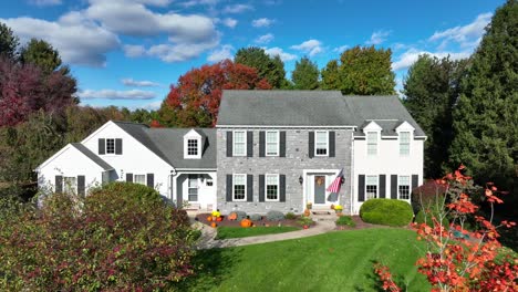 large american home with usa flag and stone architecture