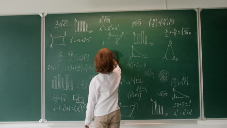 little boy erasing chalkboard.