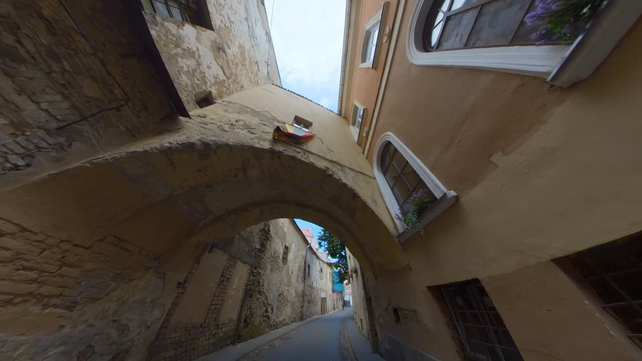 bandera lituana sobre el arco en la estrecha calle de la ciudad vieja en vilnius, lituania