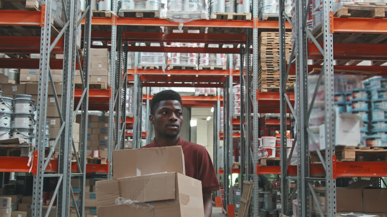 Slowmo of Black Warehouse Worker Carrying Boxes