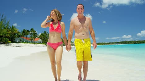 una pareja caucásica en trajes de baño en vacaciones de lujo en la playa.
