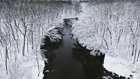 as the drone gracefully ascends above the tranquil midwest countryside, a pristine winter wonderland unfolds