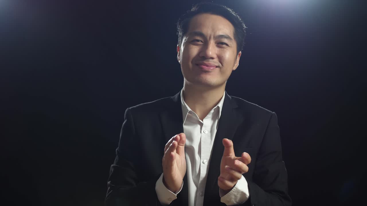 사업복 을 입은 남자 가 박수 를 치고 있다