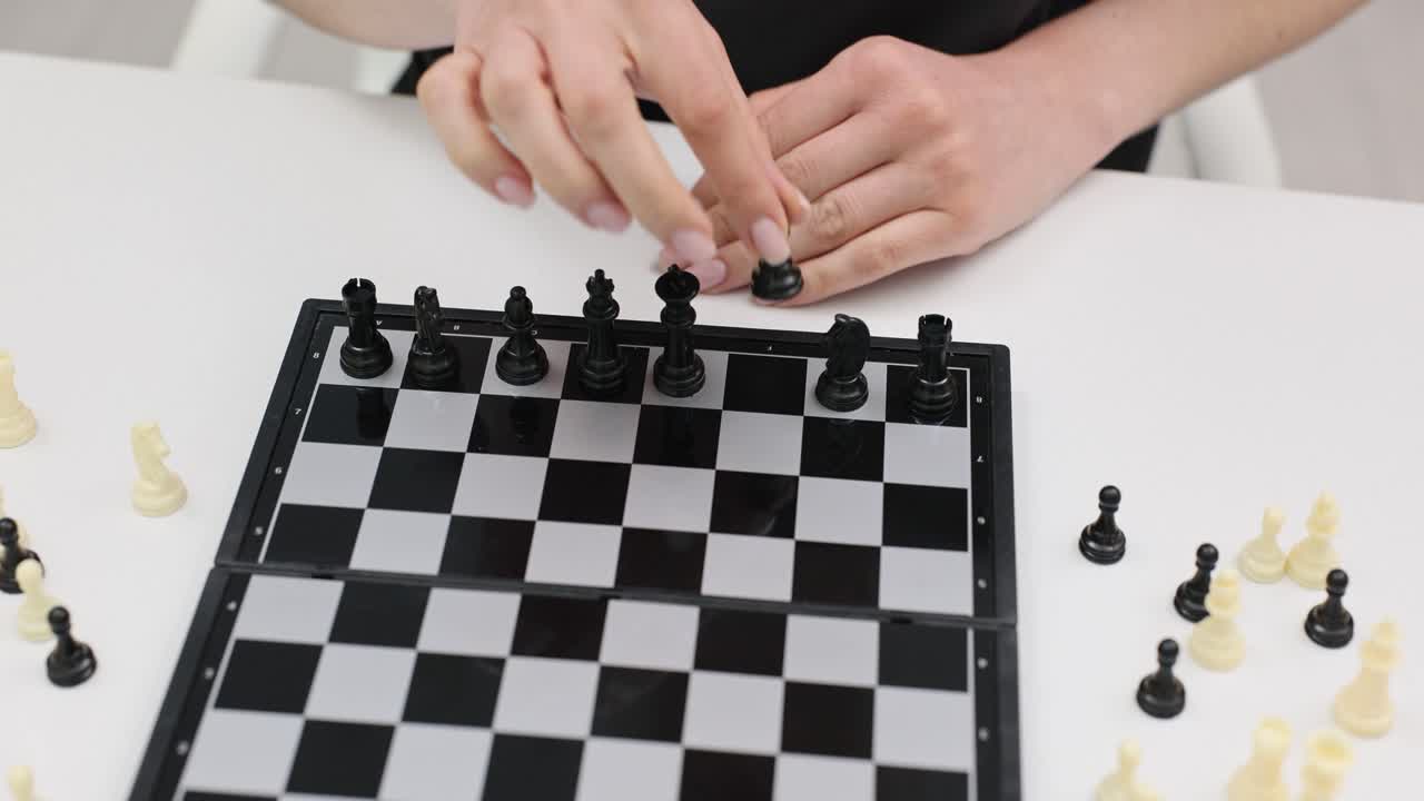 Hands playing chess on a chessboard