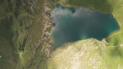 aerial overhead reveal shot of mountain lake lago grande on a sunny day