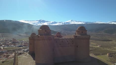 Luftaufnahme-Der-Burg-Von-La-Calahorra-Mit-Sierra-Nevada-Dahinter-In-Granada,-Spanien