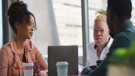 diverse business people discussing with takeaway coffee and documents in creative office