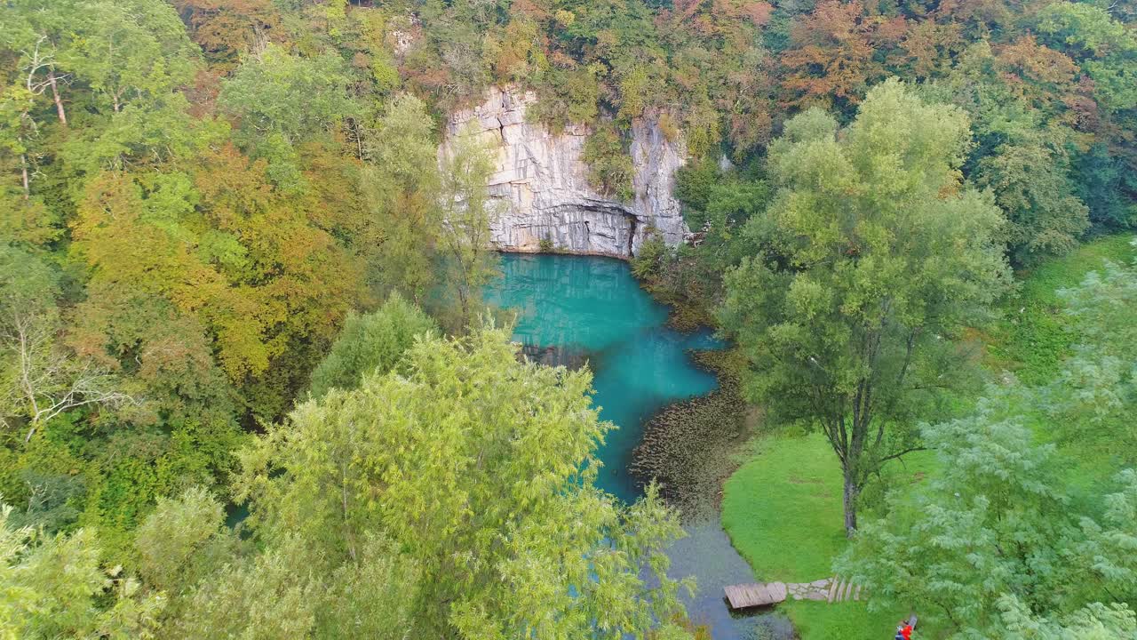 Breathtaking aerial view of blue waters of Krupa river under rock wall amidst dense greenery in Semic, Slovenia